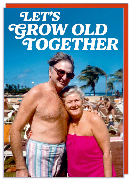 A Valentines card featuring a couple of an old couple in their swimsuits on a busy beach