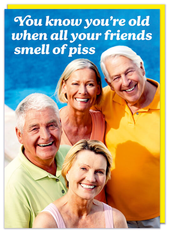 A birthday card with a picture of a smiling group of senior citizens in the sun.  White text above them reads You know you're old when all your friends smell of piss