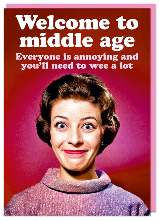 A birthday card with a picture of a smiling older woman in a blouse against a deep pink background.  White and light pink text above her reads Welcome to middle age.  Everyone is annoying and you'll need to wee a lot