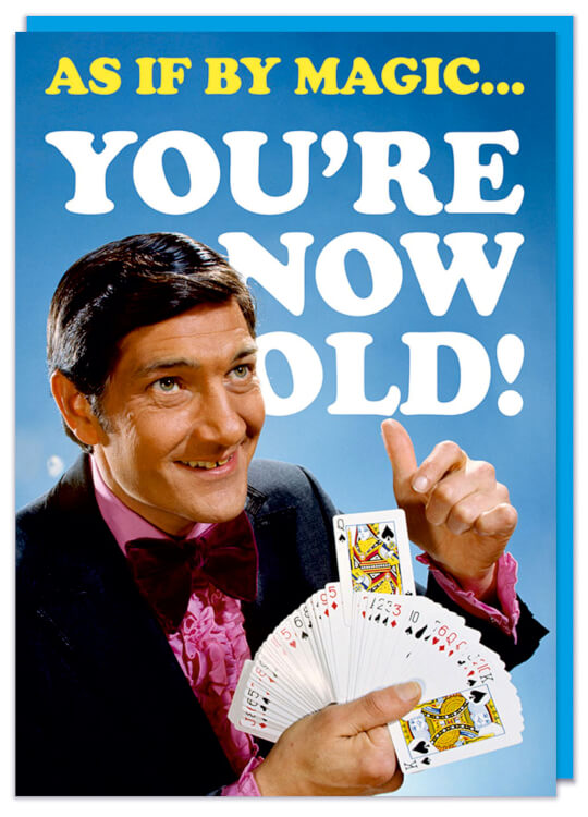 A funny birthday card with a retro picture of a smiling male magician holding a deck of cards.  White and yellow text above and behind reads As if by magic you're now old!