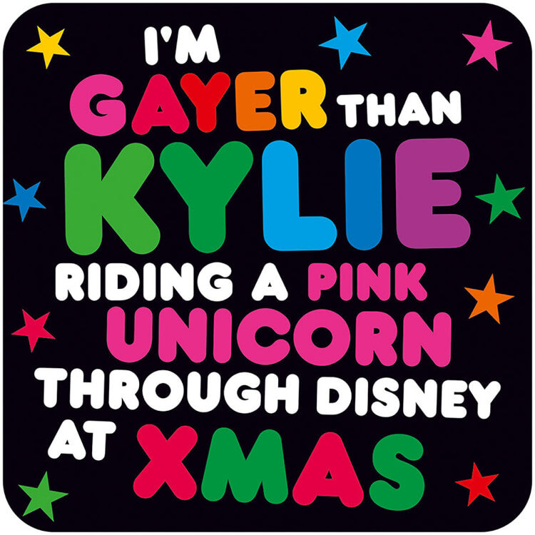 A black coaster with rounded white and rainbow text that reads I'm gayer than Kylie riding a pink Unicorn through Disney at Xmas