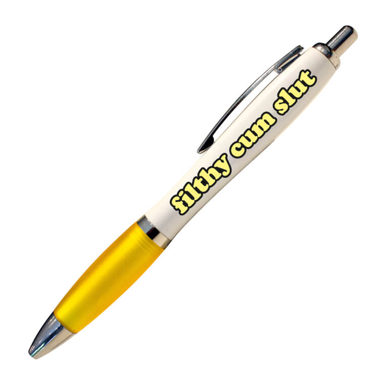 A white ballpoint pen with a yellow grip and black ink. Curvy pale yellow text with a black outline reads Filthy cum slut