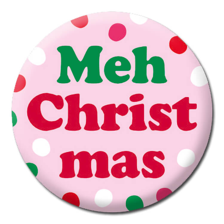 A light pink badge with red, white and green spots surrounding red and green text that reads Meh Christmas