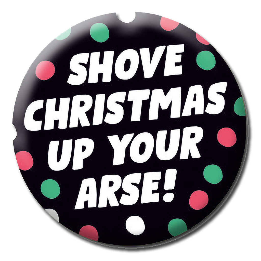 A black badge with red, green and white spots surrounding white text that reads Shove Christmas up your arse