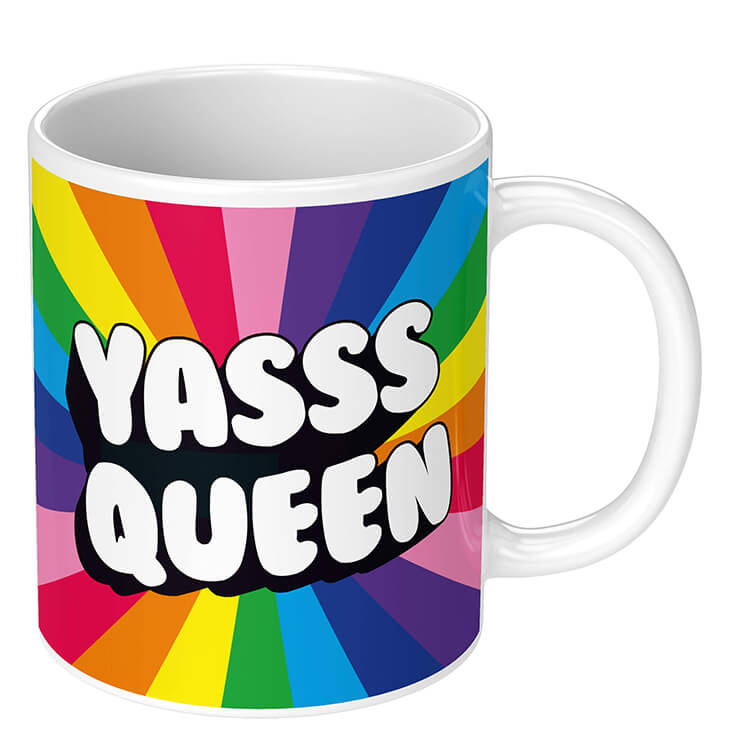 A mug with a background sunburst of ‘pride’ rainbow colours, centring on the caption ‘Yasss queen’ written in chunky bold white 3D style letters in black relief