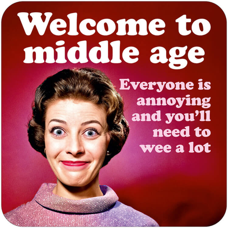 A retro coaster with a picture of a smiling older woman in a blouse against a deep pink background.  White and light pink text above and beside her reads Welcome to middle age.  Everyone is annoying and you'll need to wee a lot