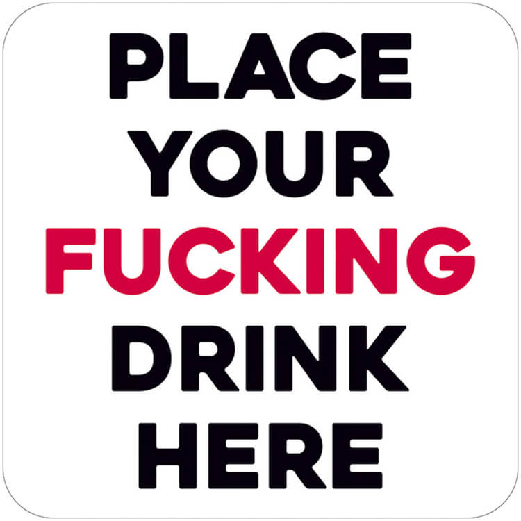 A plain white coaster with bold black and red capitalised text that reads Place your fucking drink here