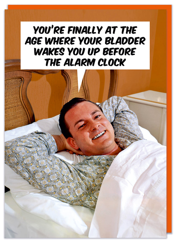 A funny retro birthday card featuring a smiling man with his hands behind his head lying in bed.  He's saying You're finally at the age where your bladder wakes you up before your alarm clock