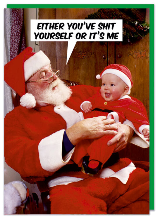 A Christmas card with a picture of Santa Claus sitting down holding a smiling baby in a mini father Christmas outfit