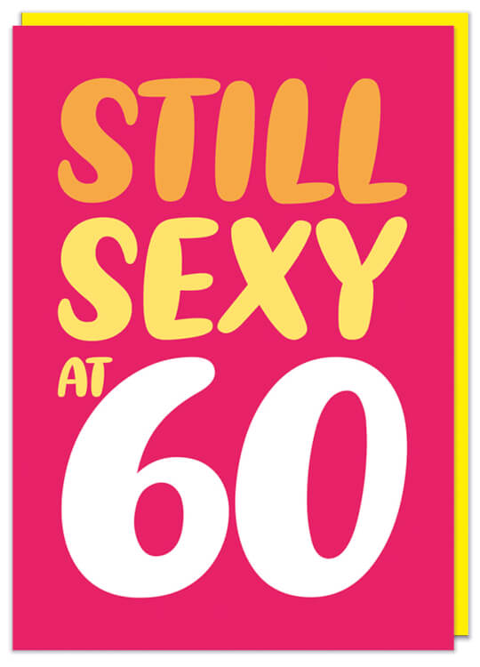 A bright red birthday card with orange, yellow and white rounded letters that reads Still sexy at 60
